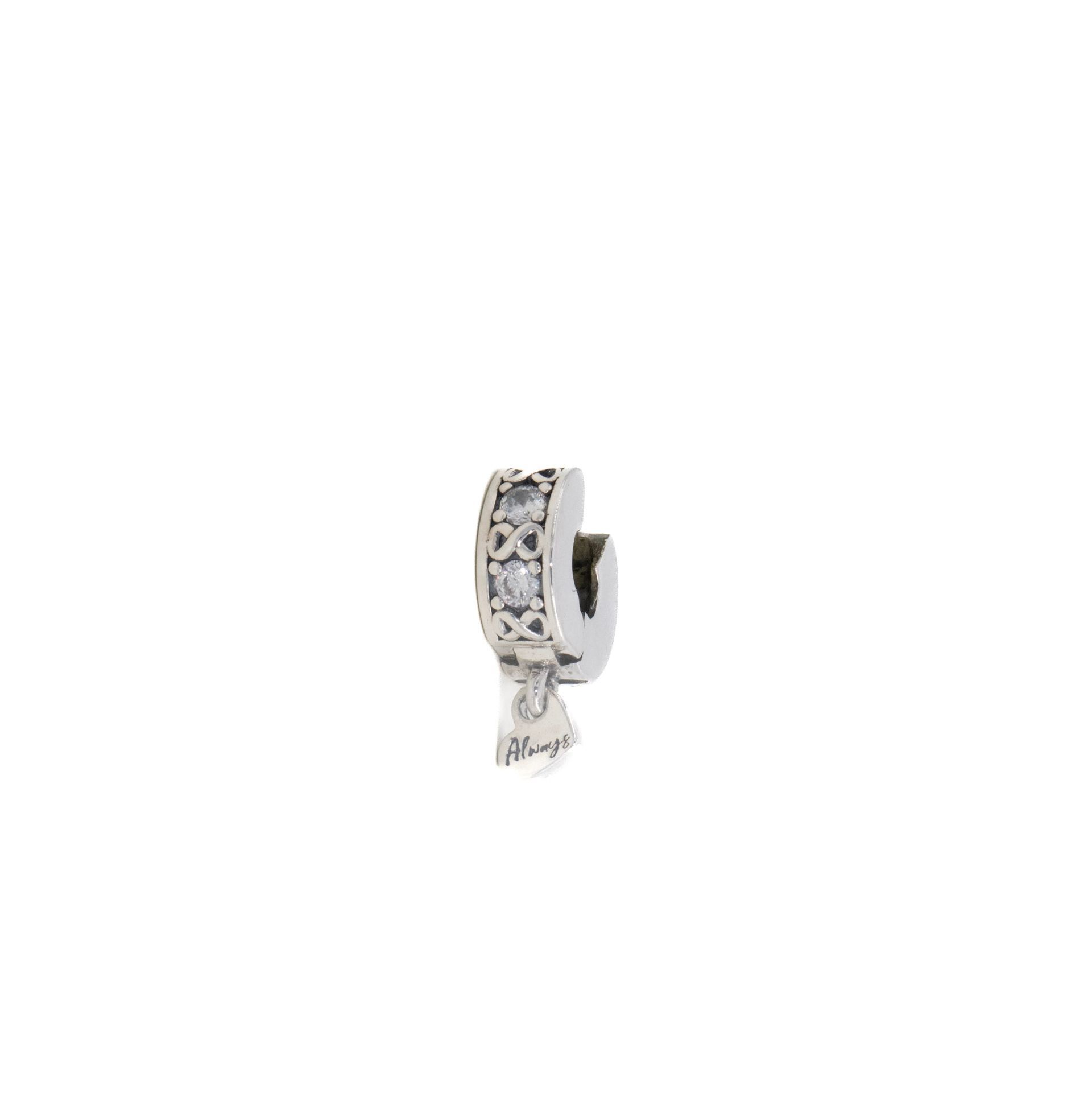 Pendiente de aro pequeño de plata con piedras transparentes y un colgante de borla.