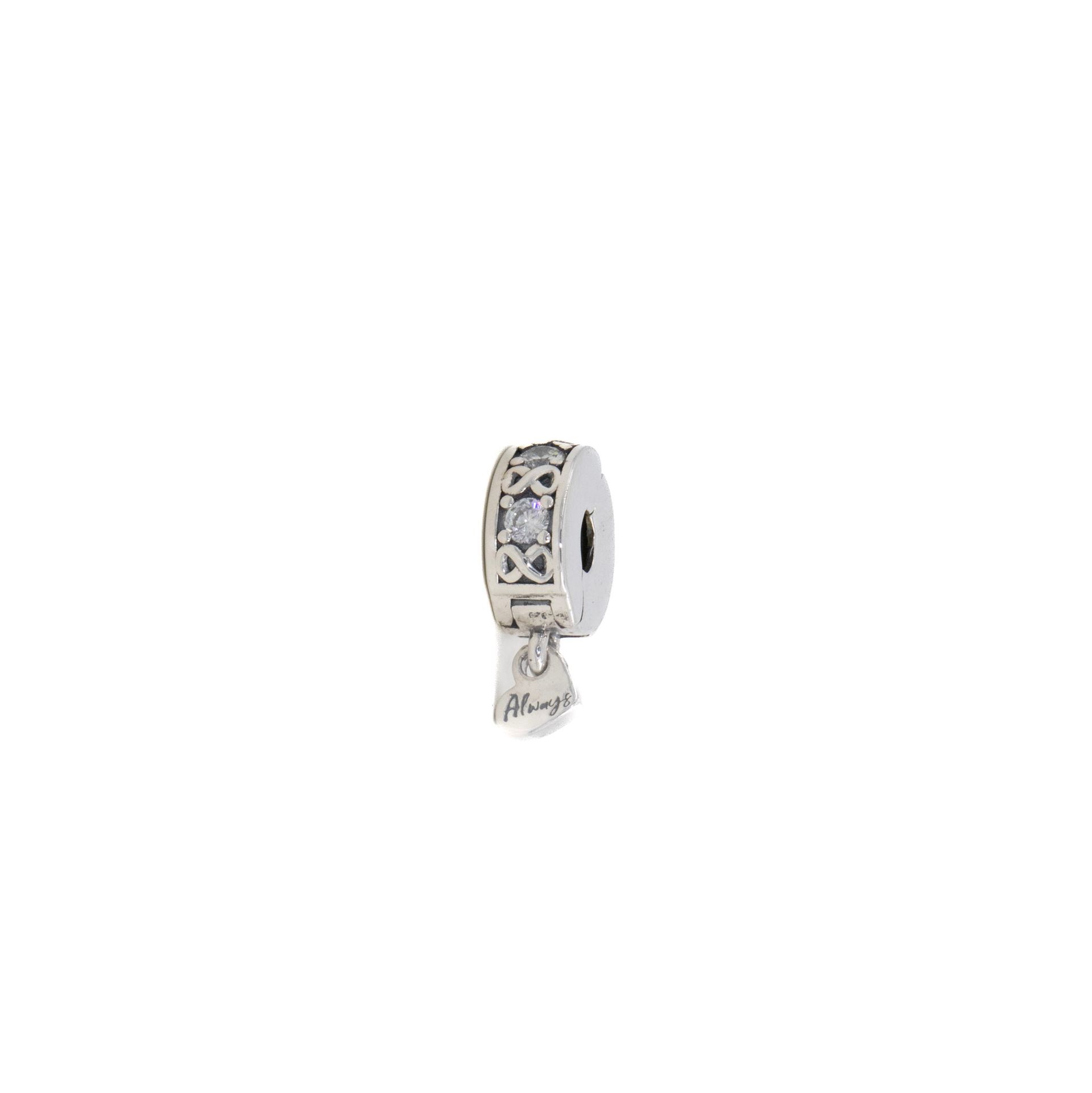 Pendiente de aro pequeño de plata con piedras transparentes y un colgante de borla.