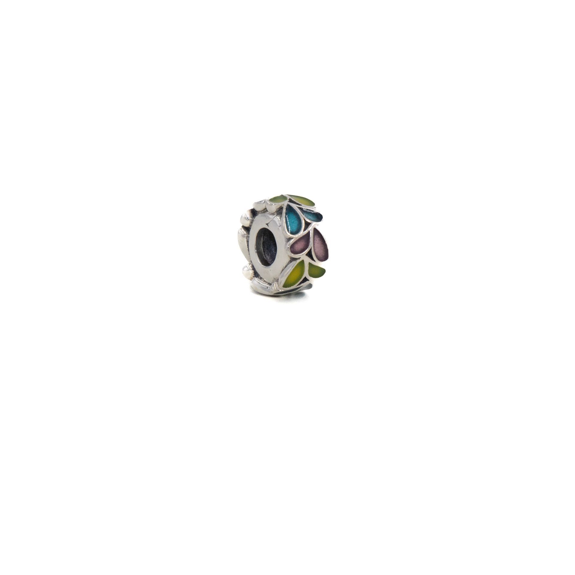 Pequeño dije de plata con detalles multicolores en forma de pétalos sobre fondo blanco.