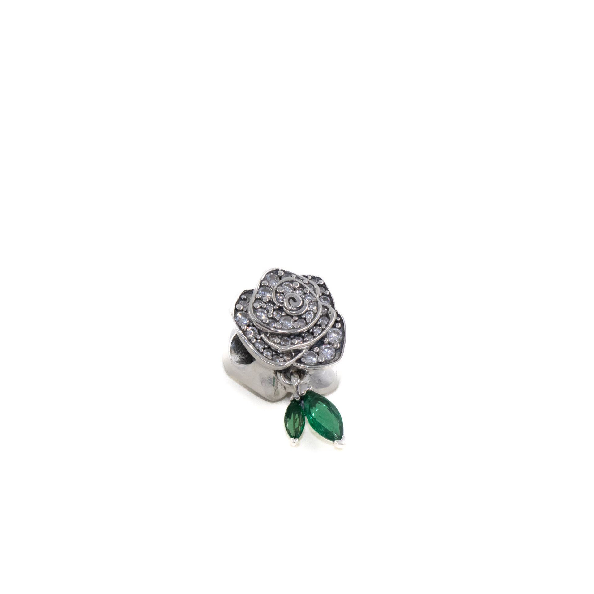 Anillo de plata con un grupo de diamantes en forma de rosa y dos detalles de hojas verdes.