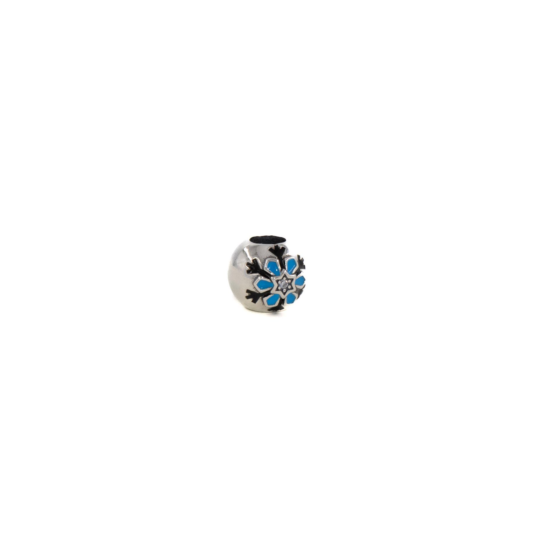 Pequeño dije de plata con detalles florales azules y espirales negras sobre fondo blanco.