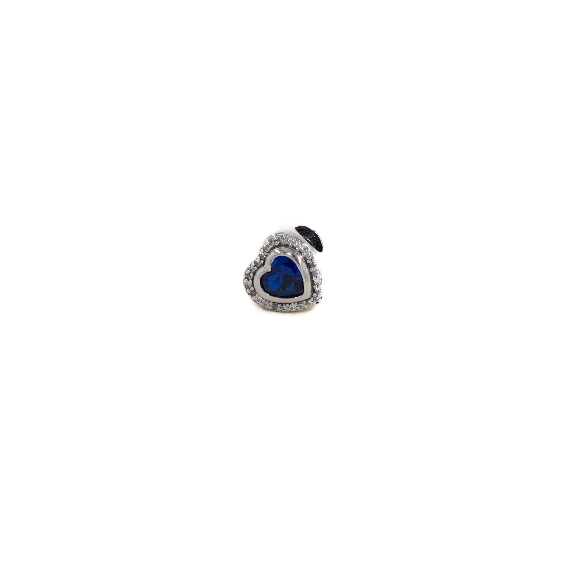 Anillo con gema azul en forma de corazón con engaste de plata y pequeñas piedras transparentes.