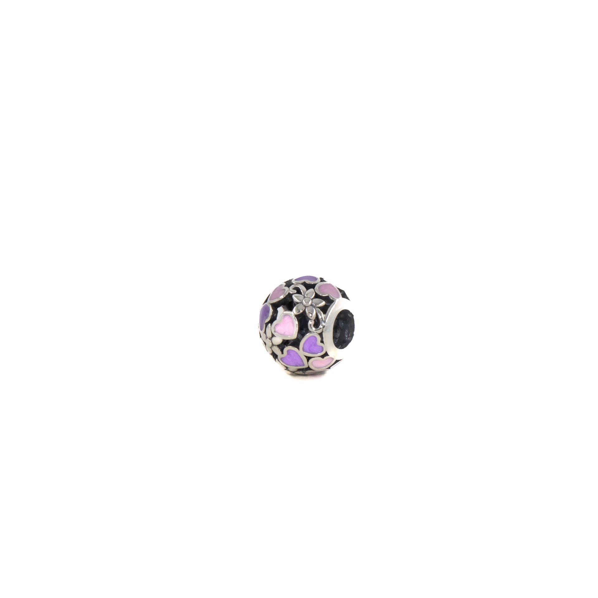 Pequeño dije de plata con detalles florales en rosa y negro sobre fondo blanco.