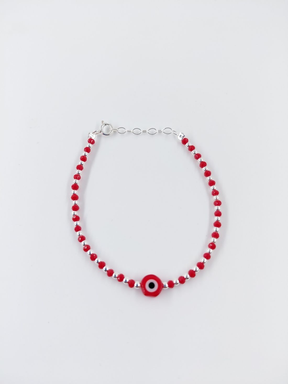 Pulsera de cuentas rojas y blancas con un dije circular rojo sobre fondo blanco.