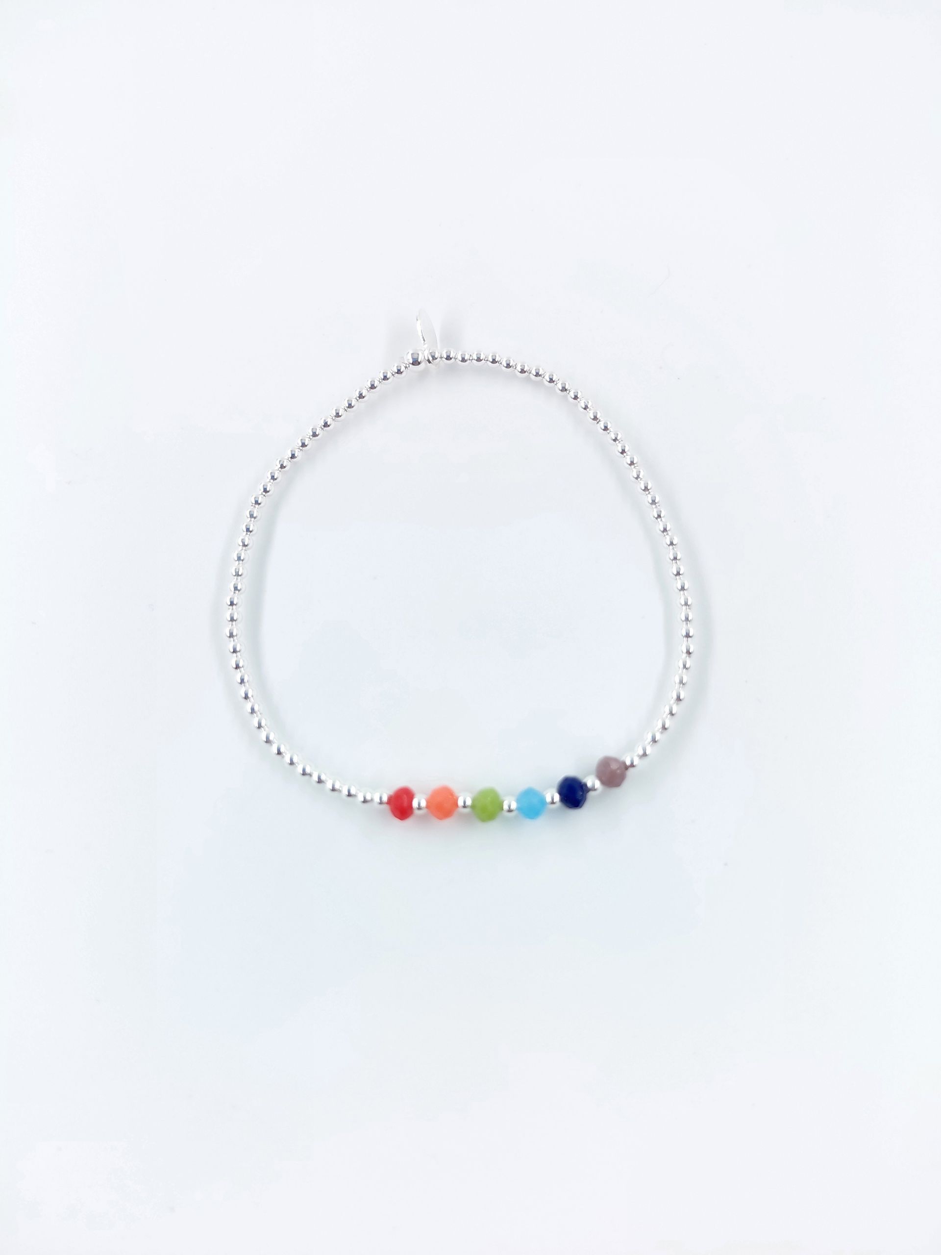 Pulsera de cuentas arcoíris con cadena de plata sobre fondo blanco