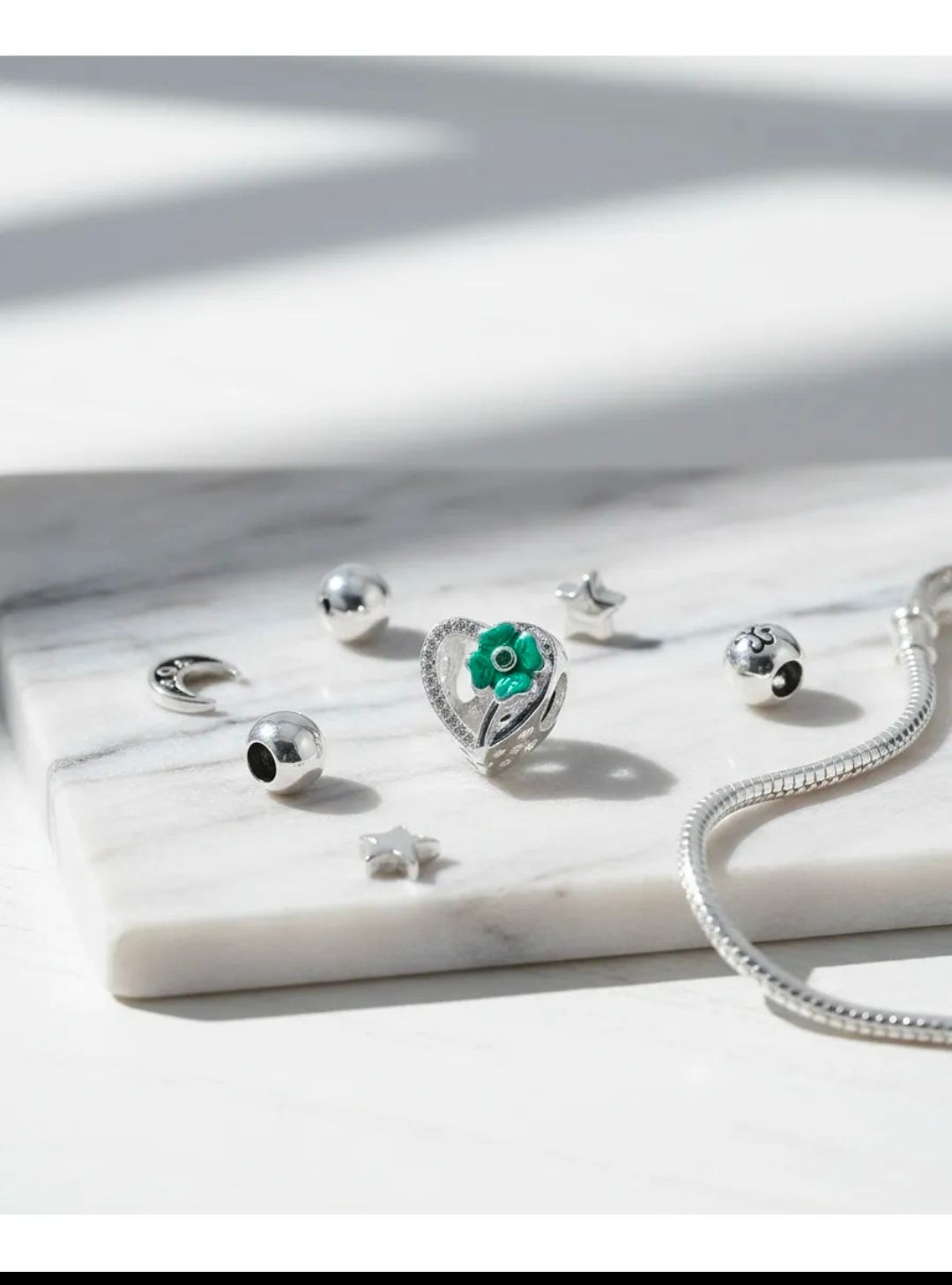 Conjunto de joyas de plata con un colgante de turquesa sobre una bandeja blanca.