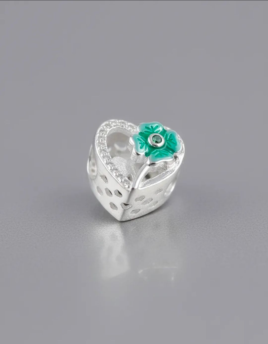Conjunto de joyas de plata con un colgante de turquesa sobre una bandeja blanca.