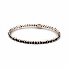 Pulsera de tenis de oro rosa con piedras negras sobre fondo blanco.