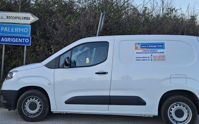 Furgone bianco per le consegne parcheggiato vicino ai cartelli stradali che indicano Palermo e Agrigento.