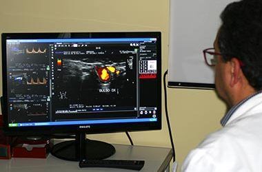 Persona che visualizza una scansione medica su un monitor in un ambiente clinico.