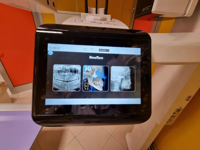 Schermo touchscreen a parete che mostra un'interfaccia di navigazione con mappa in una stanza rossa e bianca