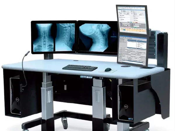 Postazione di lavoro per diagnostica per immagini medicali con doppio schermo a raggi X e monitor che visualizza il software di scansione del paziente.