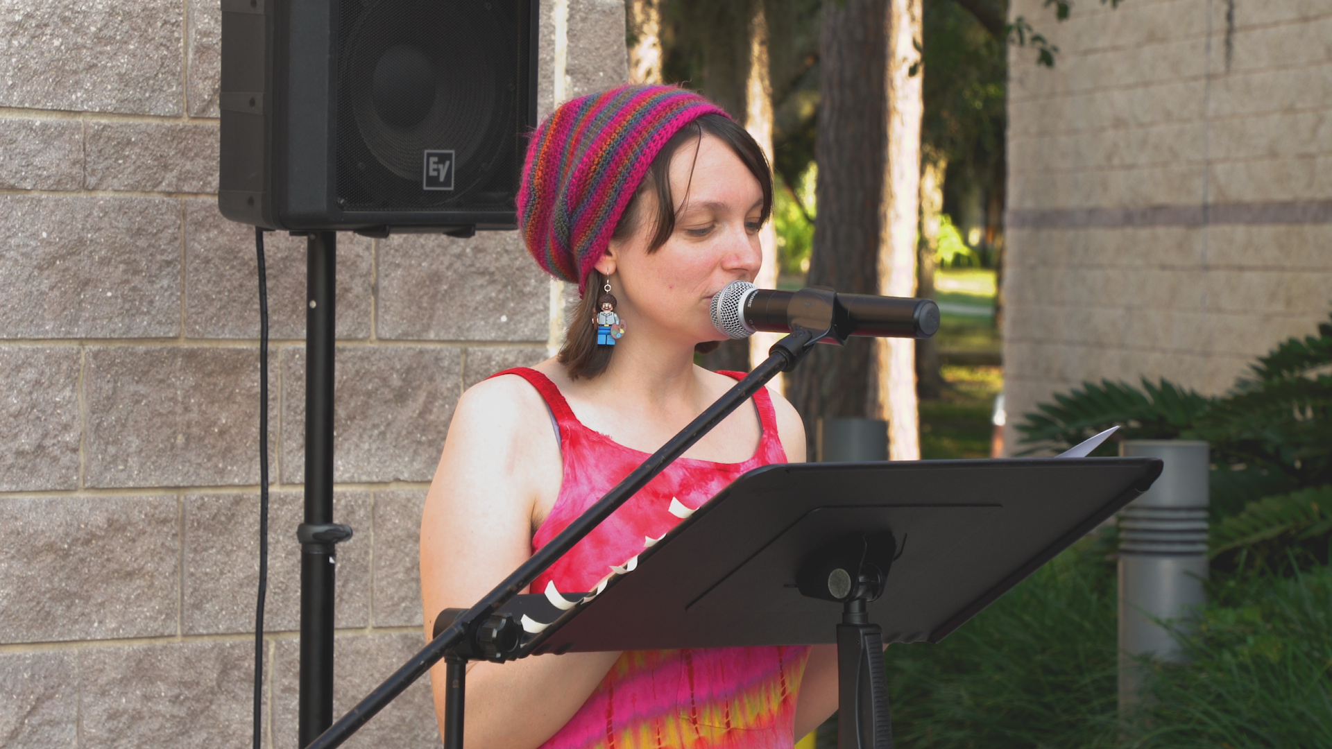A woman singing into a microphone in front of a speaker