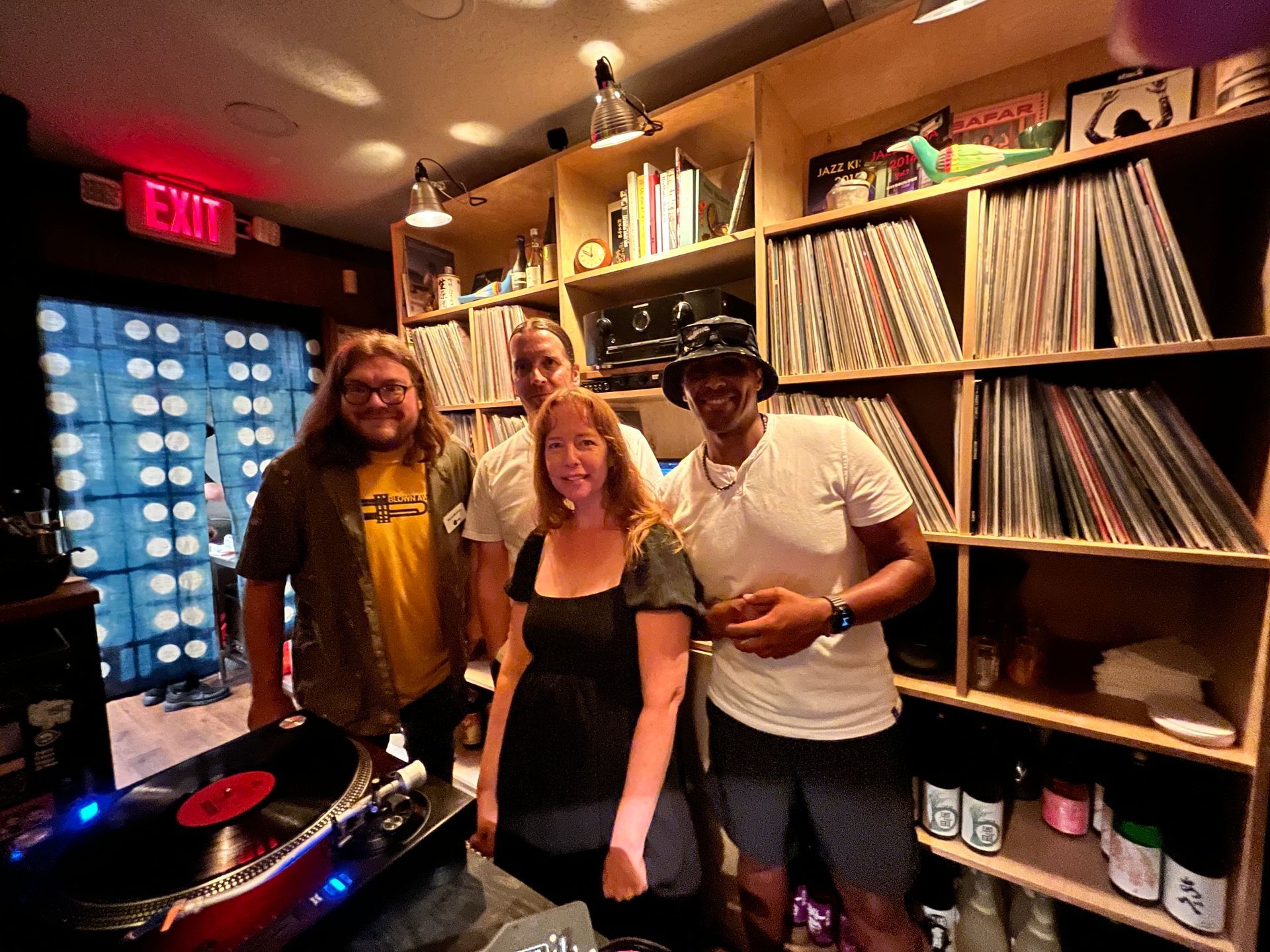 A group of people are posing for a picture in front of a record player.