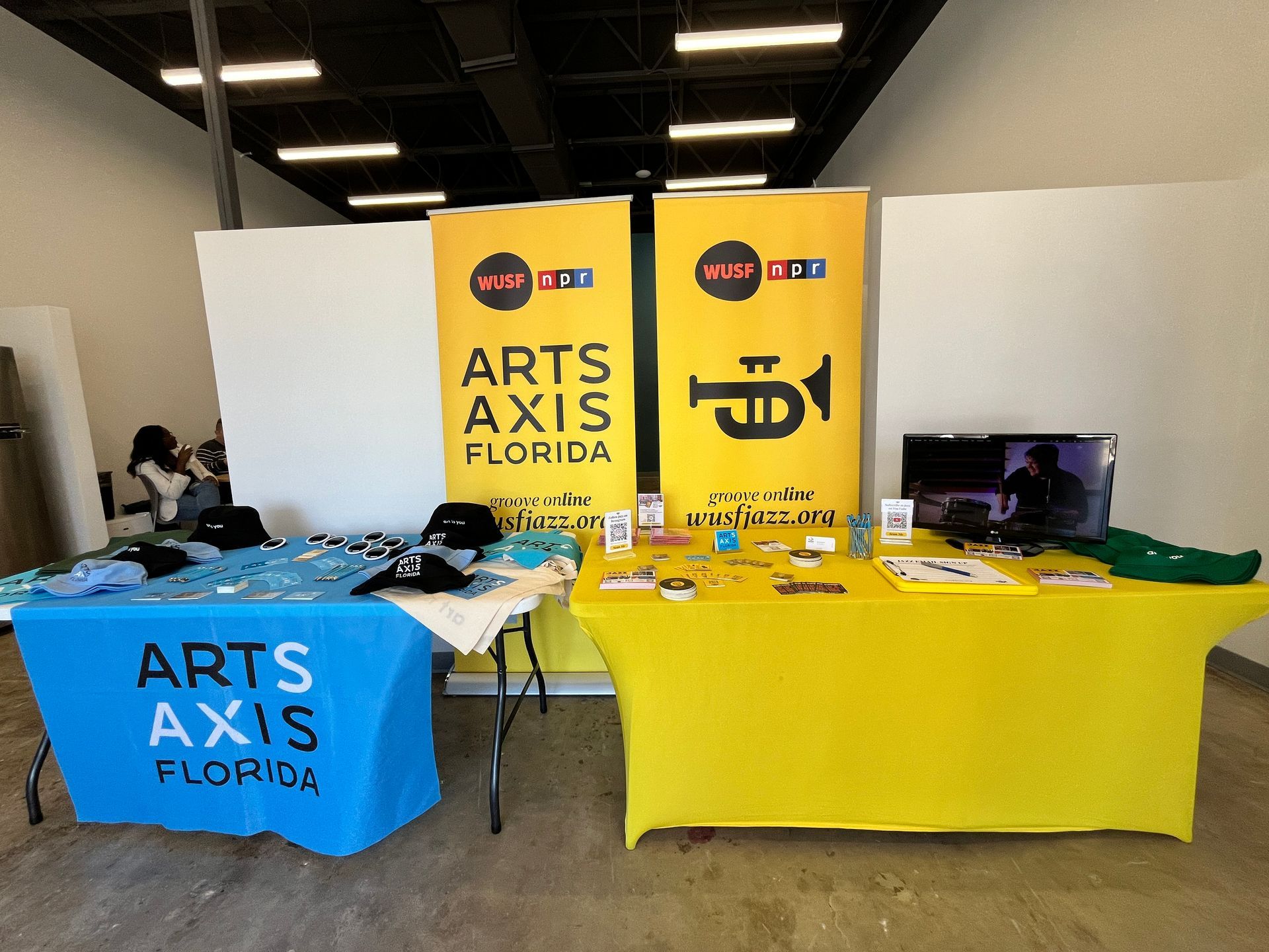 A table with a blue table cloth that says arts axis florida