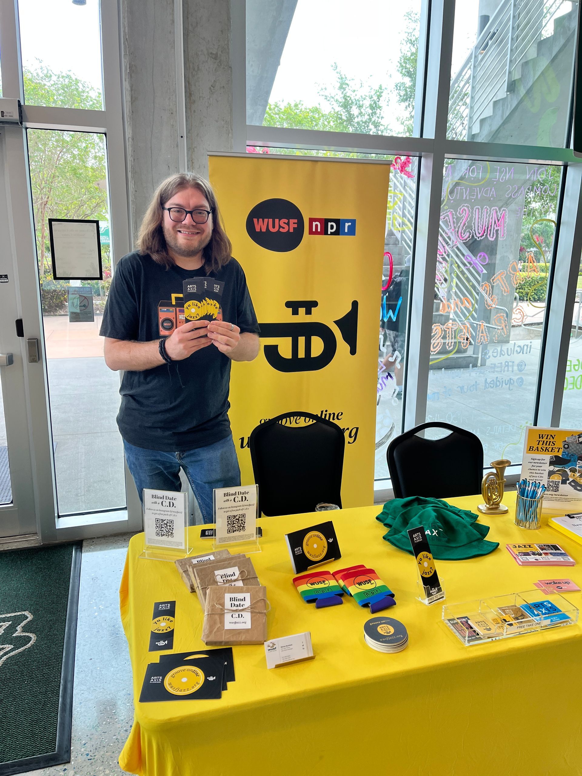 A man is standing in front of a table with a yellow table cloth.