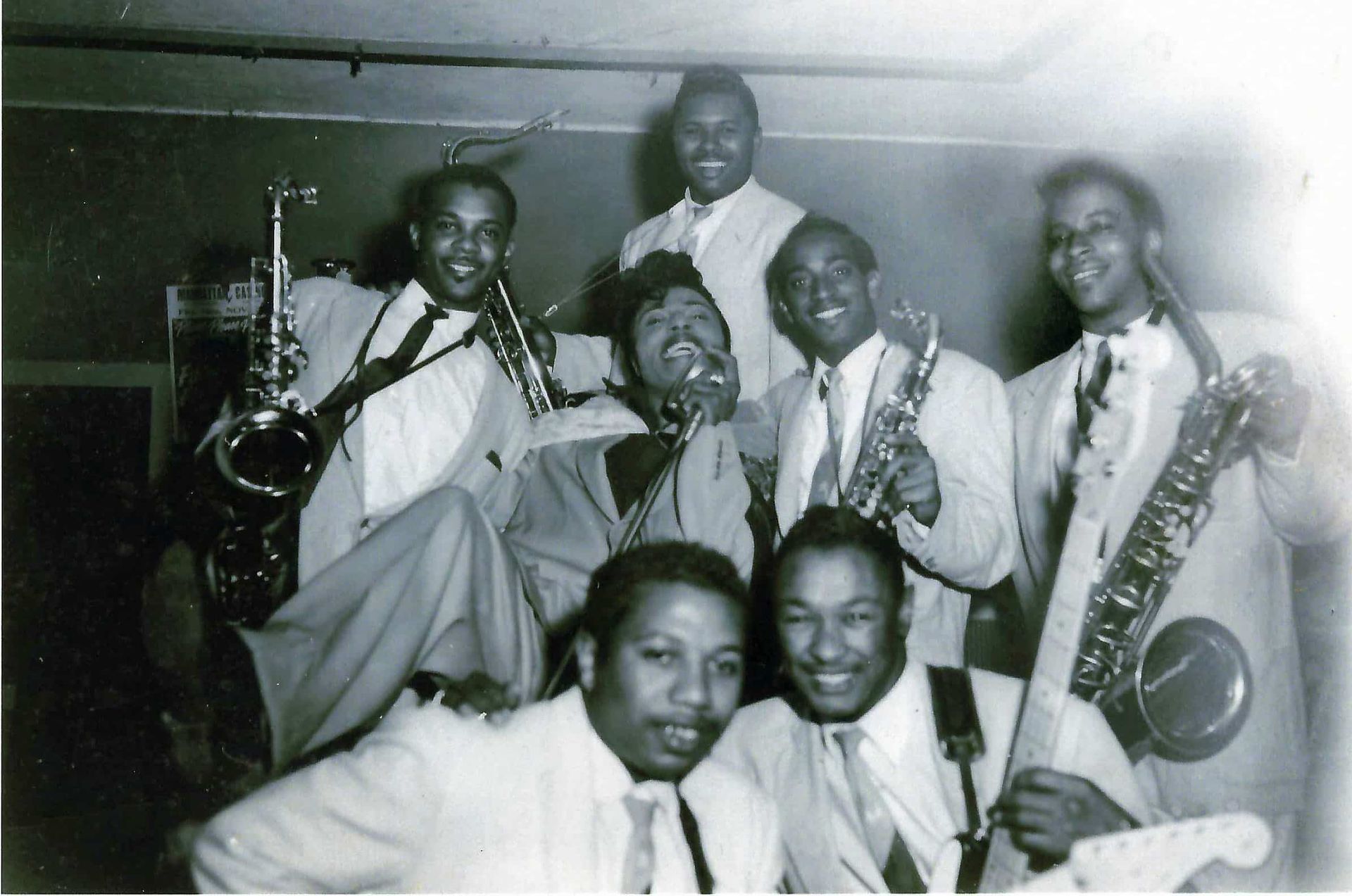 A black and white photo of a group of men playing instruments