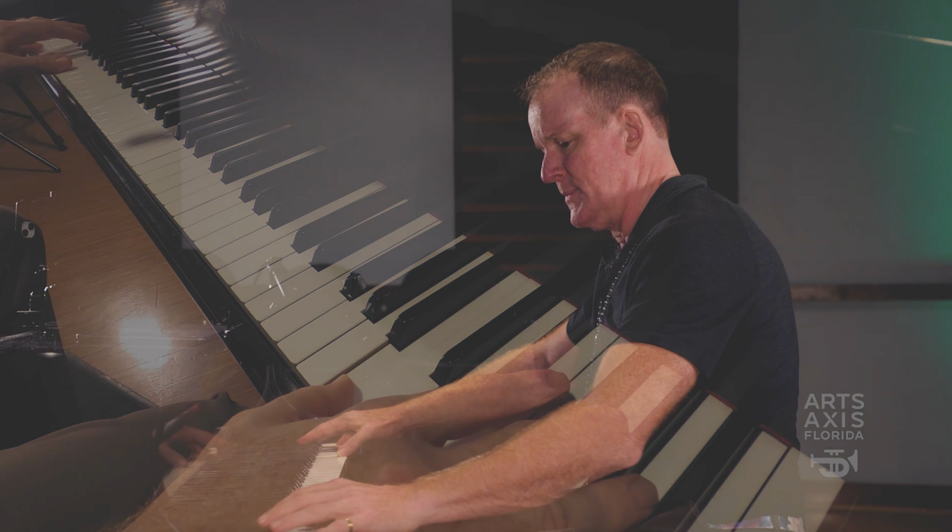 a man in a black shirt is playing a piano .