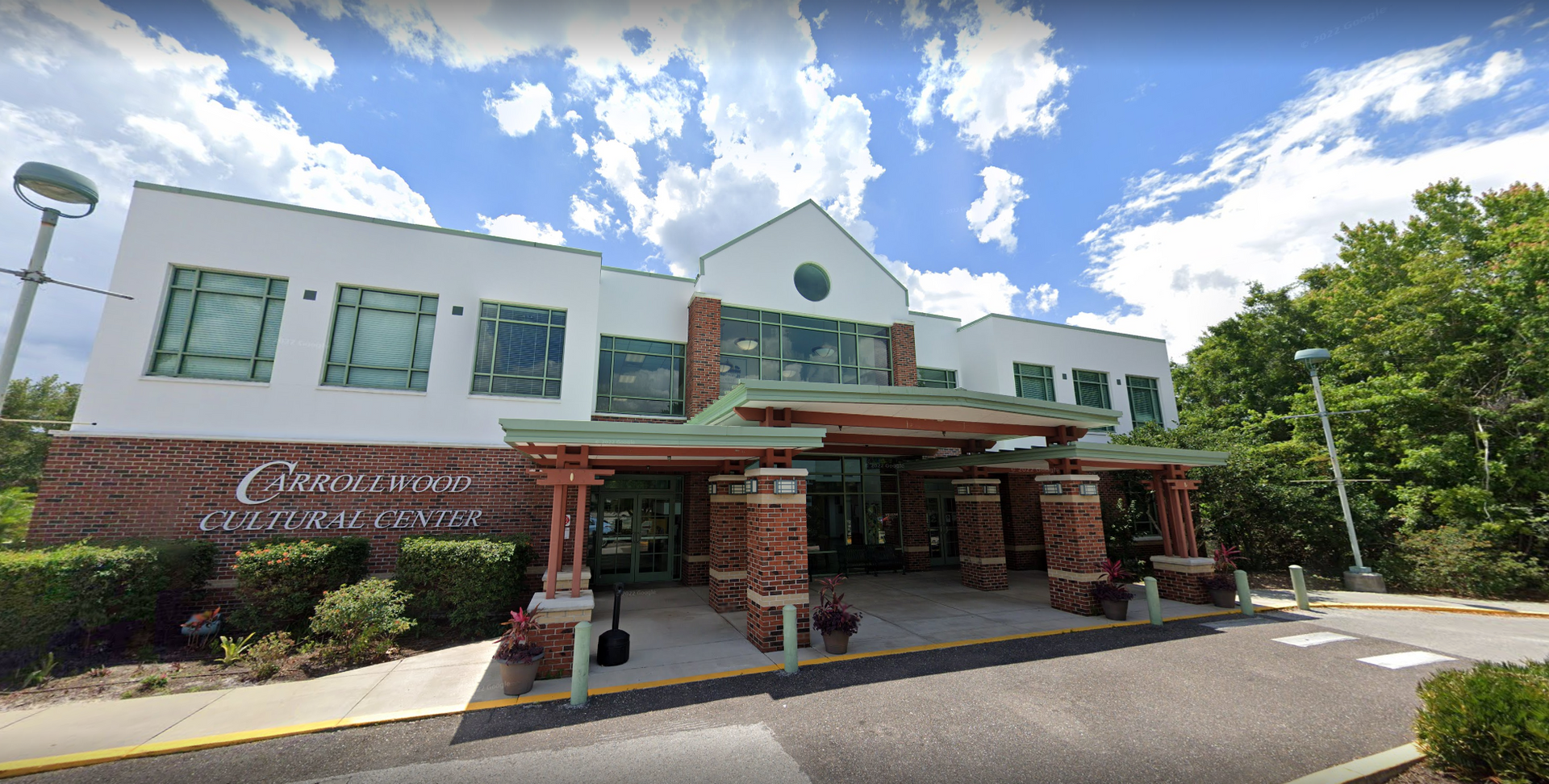 A large brick building with a lot of windows is surrounded by trees.