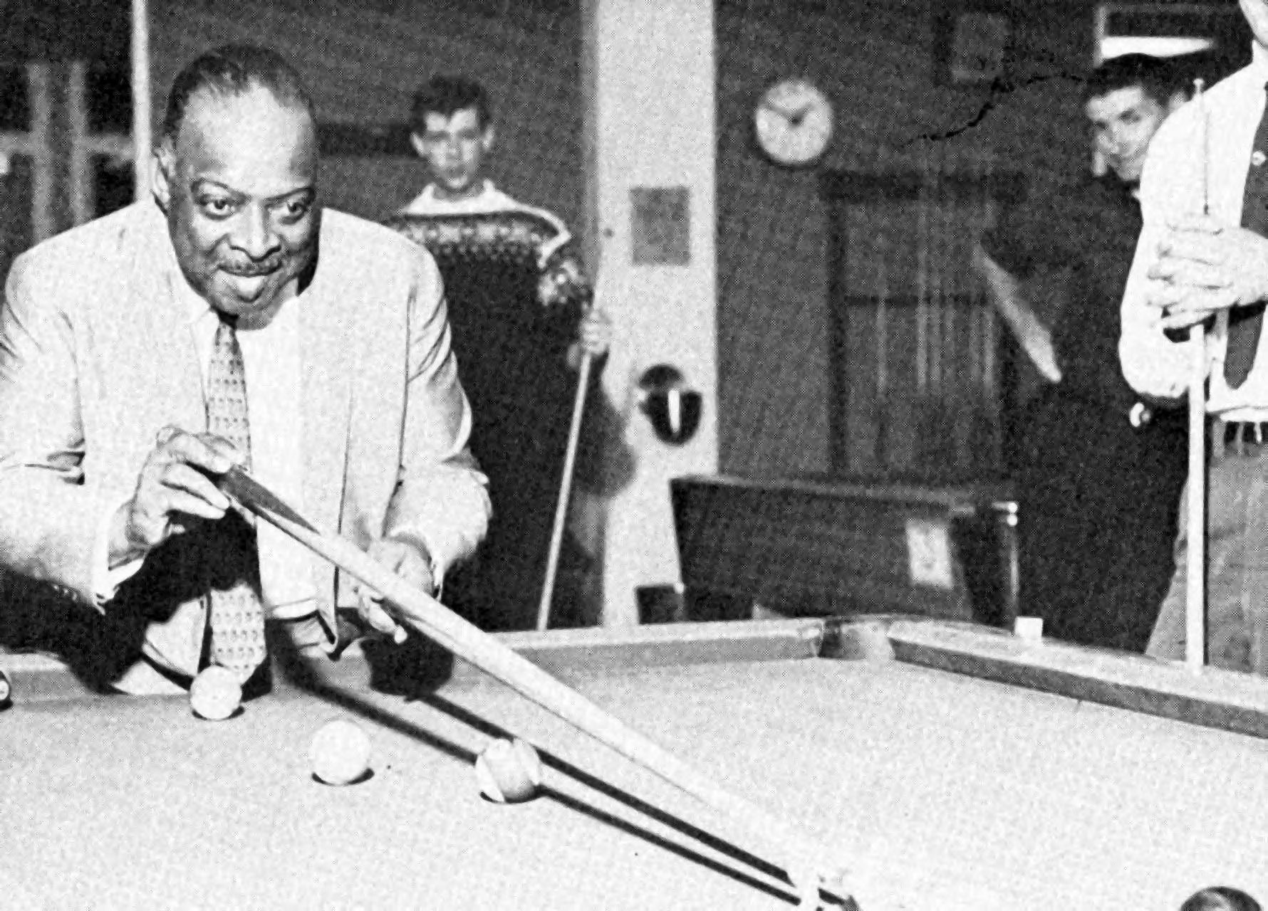 A black and white photo of a man playing pool