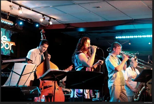 a group of people playing instruments on a stage in front of a sign that says le dor