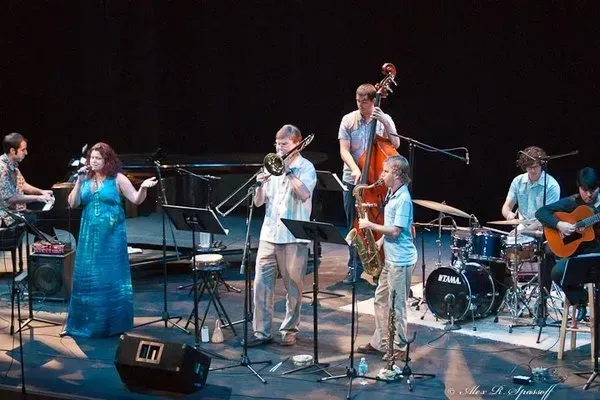 a group of people playing instruments on a stage with a tama drum in the foreground