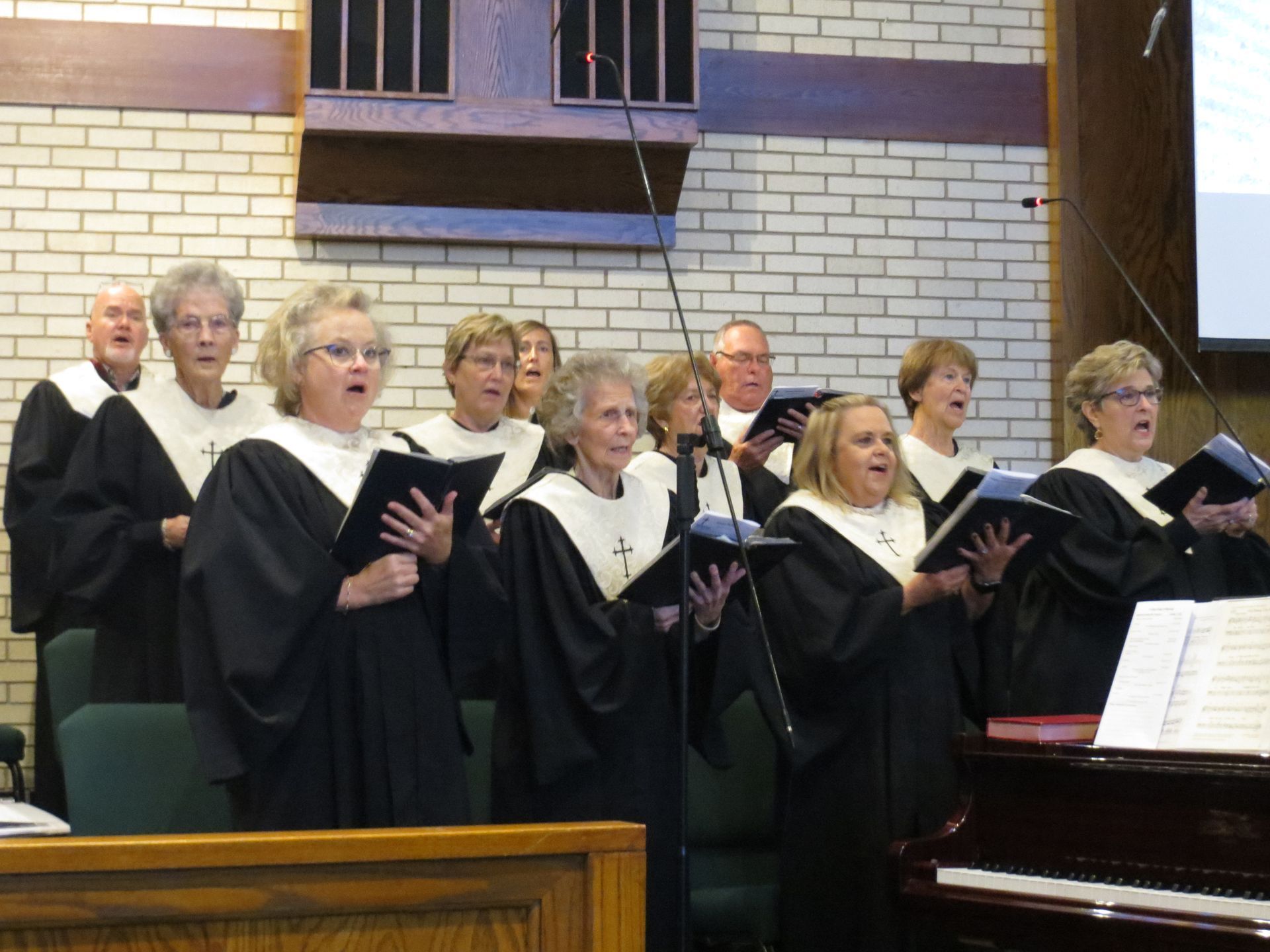 A choir is singing in front of a piano