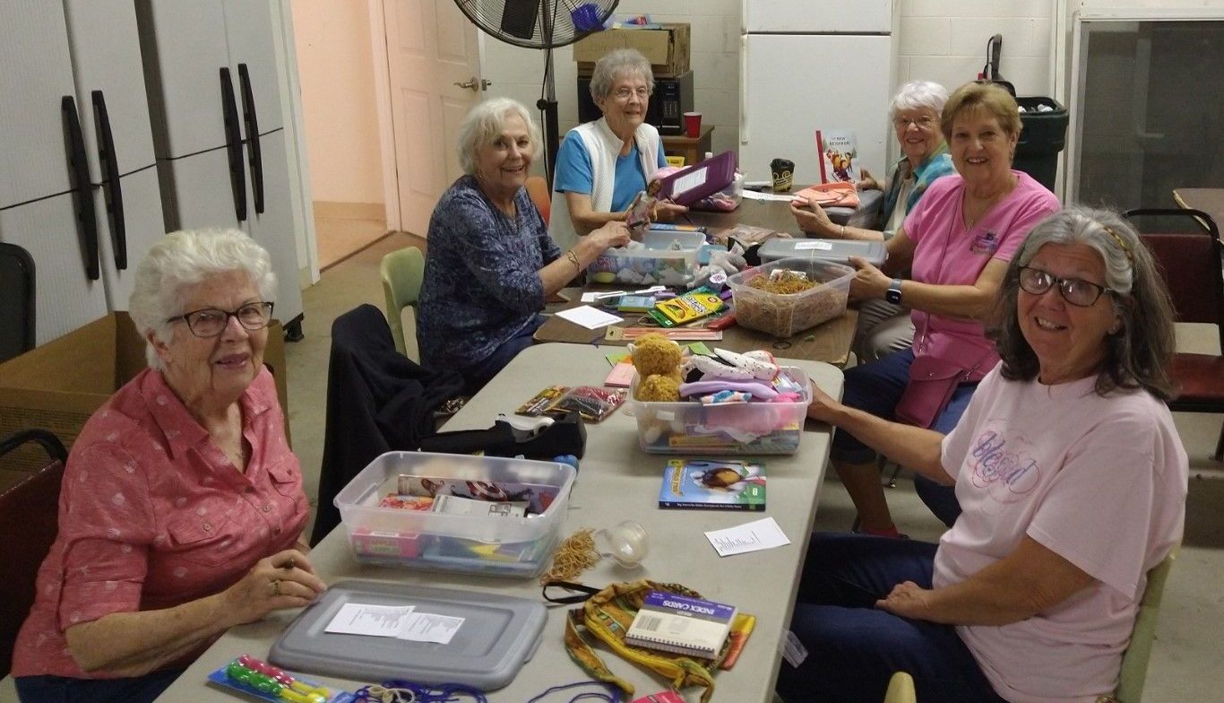 A group of older women are sitting around a table