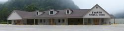 Evarts Elementary School building with a long porch and three dormer windows under an overcast sky