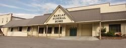 Marlan Funeral Home storefront with tan exterior and covered entrance under a cloudy sky