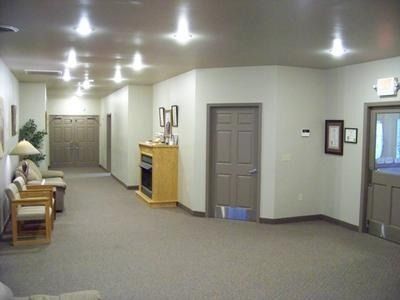 Long hallway with beige carpet, gray doors, wood console, and recessed ceiling lights
