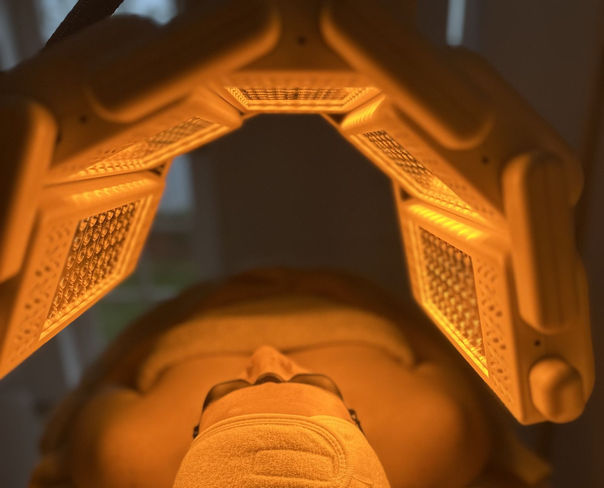 Person under orange LED light therapy device.— Bombshell Body Bar In Meikleville Hill, QLD