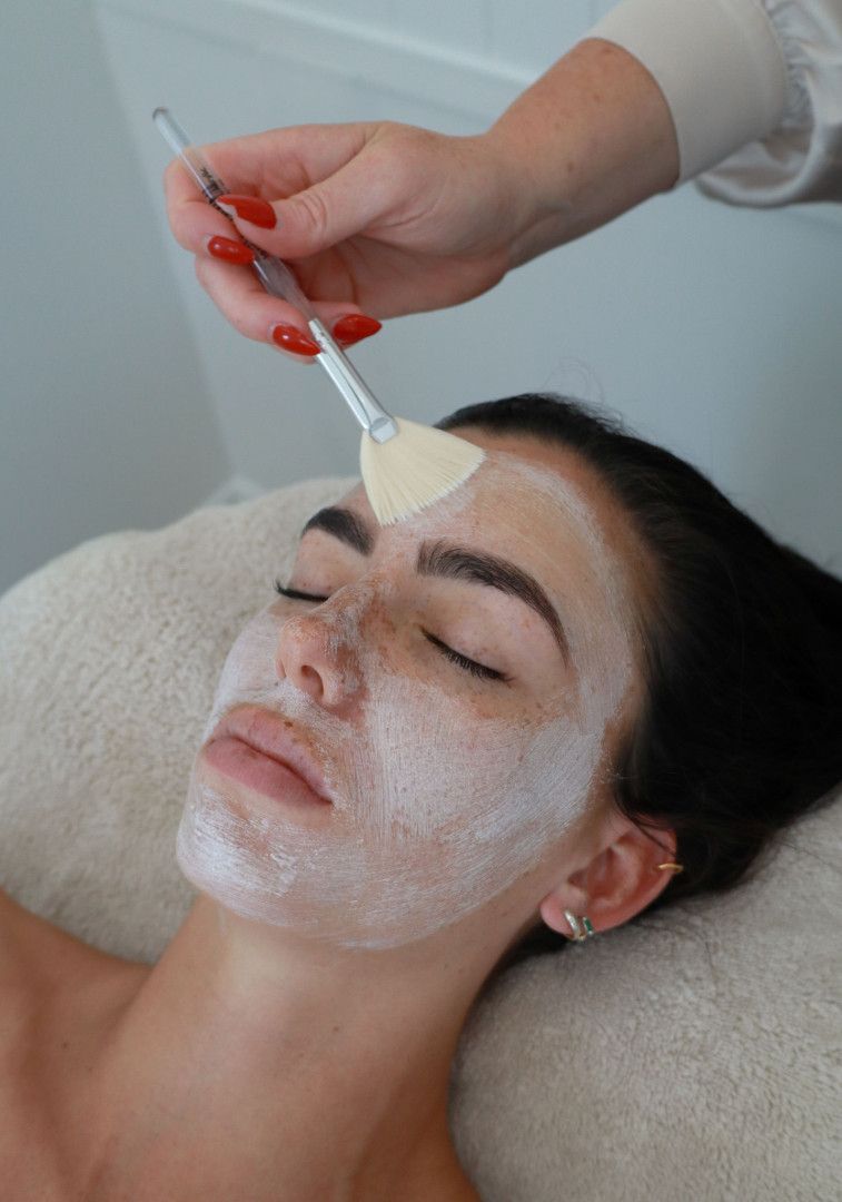 Woman receiving facial treatment; spa setting; cream mask applied with a brush.— Bombshell Body Bar In Meikleville Hill, QLD