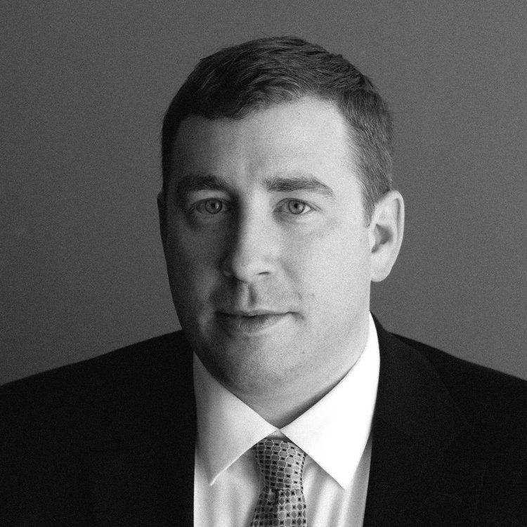 a man in a suit and tie looks at the camera