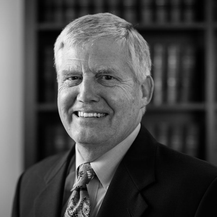 a man in a suit and tie is smiling in a black and white photo