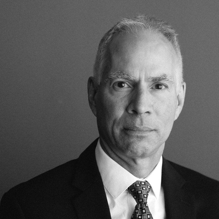a man in a suit and tie looks at the camera