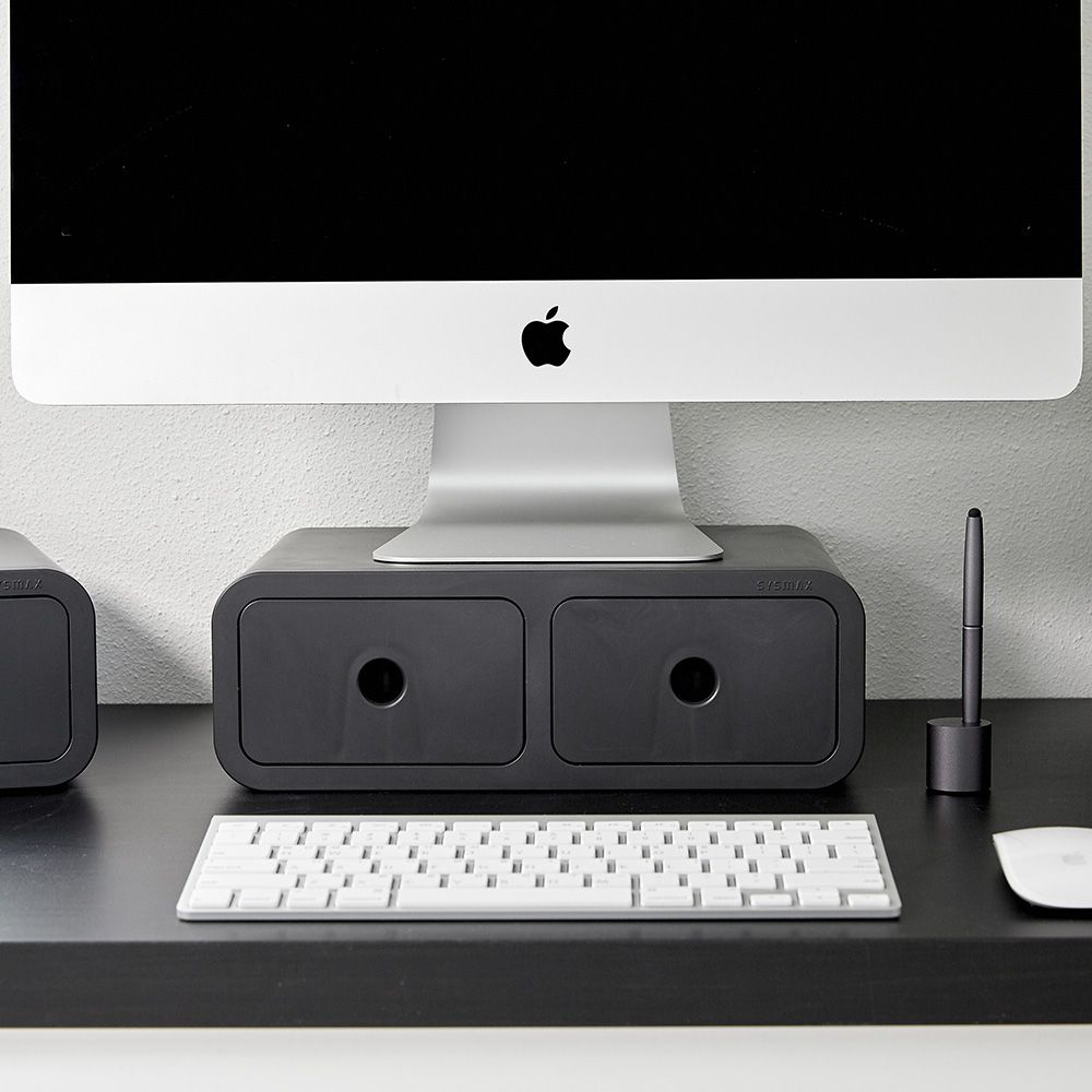 Un ordenador Apple está encima de un organizador de escritorio con cajones.