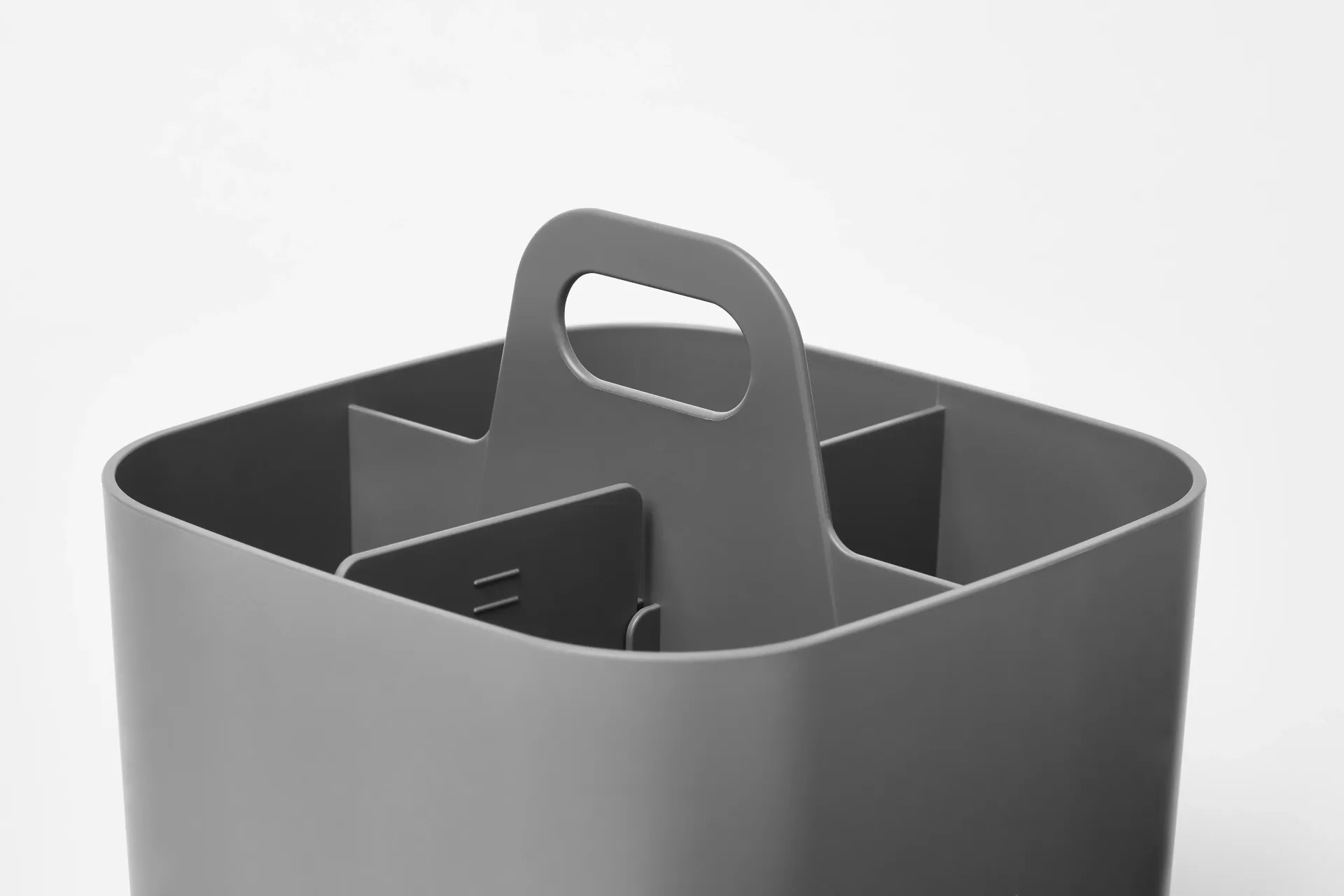Un recipiente de plástico gris con un asa y cuatro compartimentos.