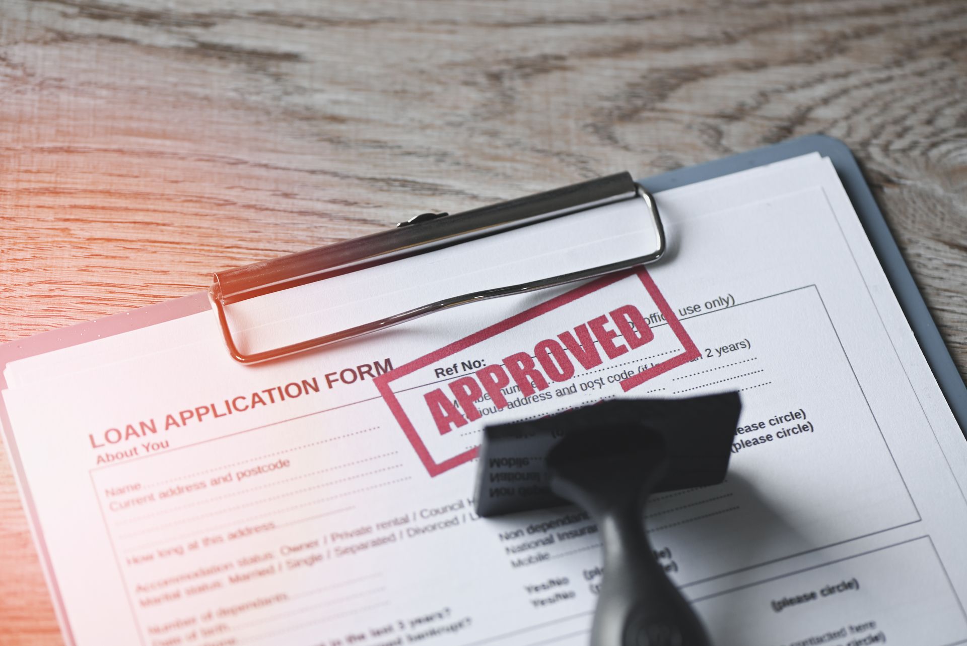 Approved loan application form stamped and placed on a desk. Approved loan application form stamped and placed on a desk.