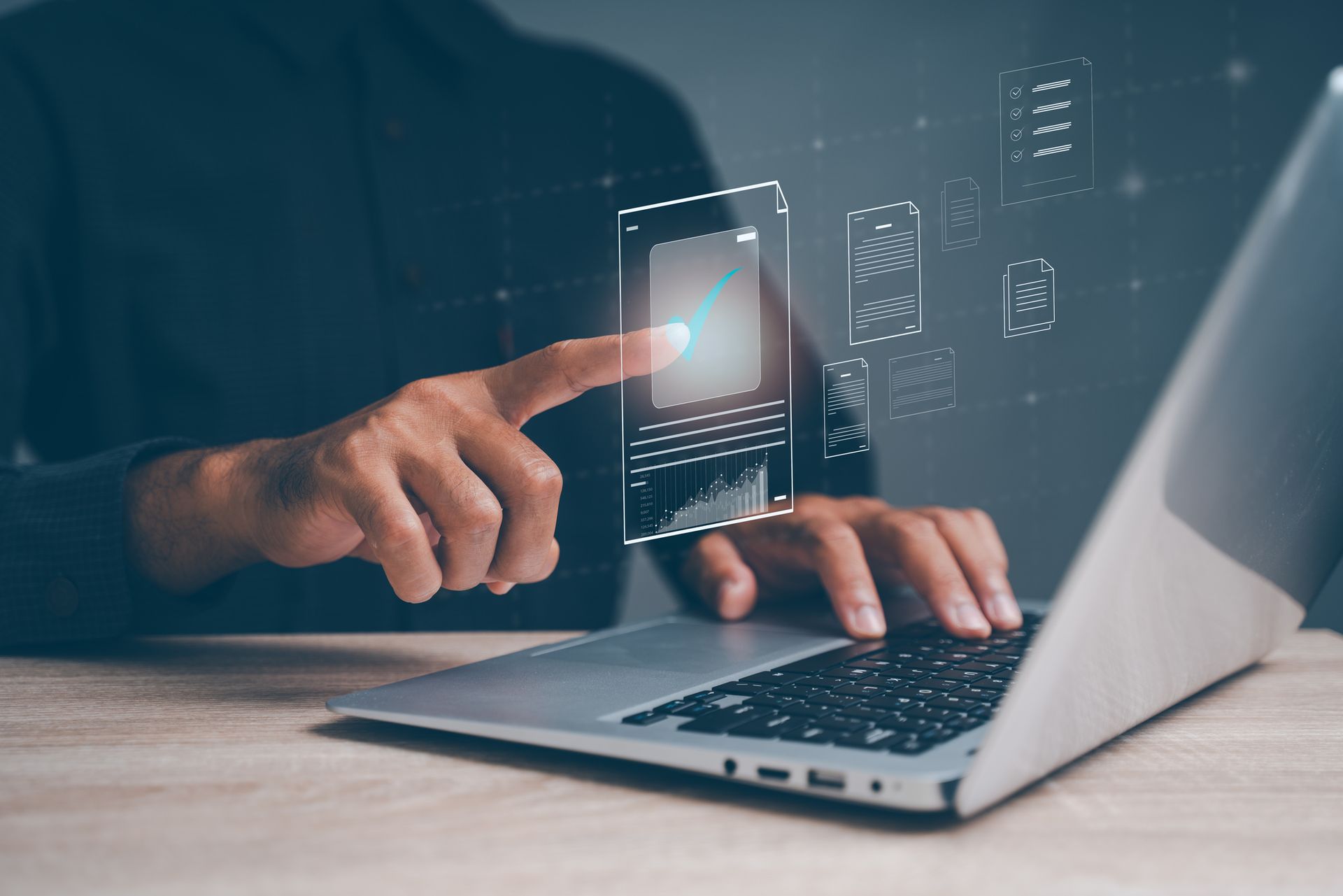 Person using laptop with virtual data charts and graphs on screen.