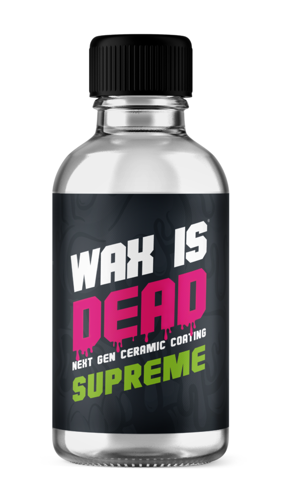 Clear bottle labeled “WAX IS DEAD” with pink and green text on a black label, black cap.