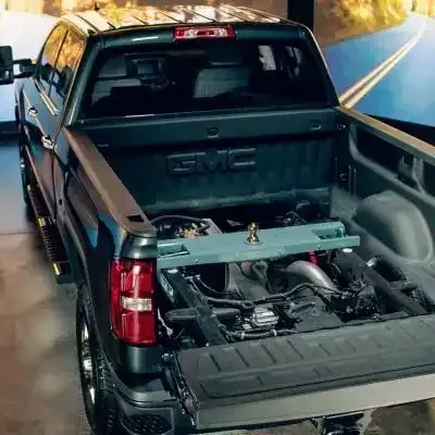 A gmc truck with the bed open and the engine visible.
