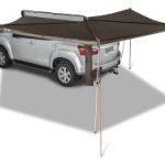 A silver truck is parked under an umbrella on a white surface.