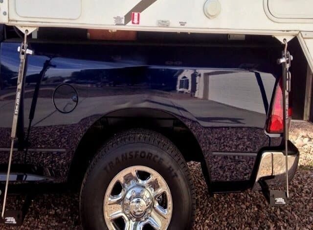 A black truck with a trailer attached to it