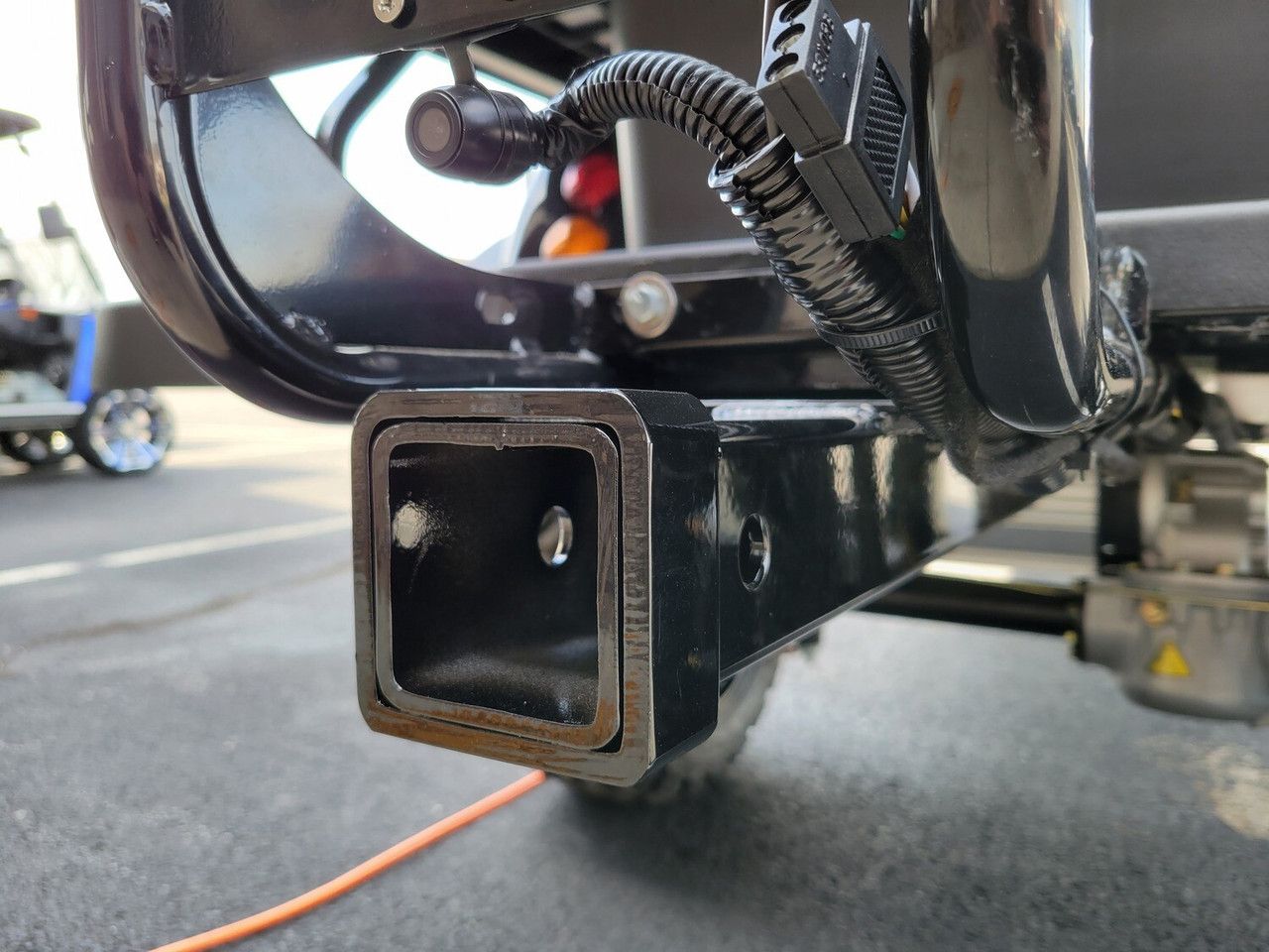 A close up of a trailer hitch on a golf cart.