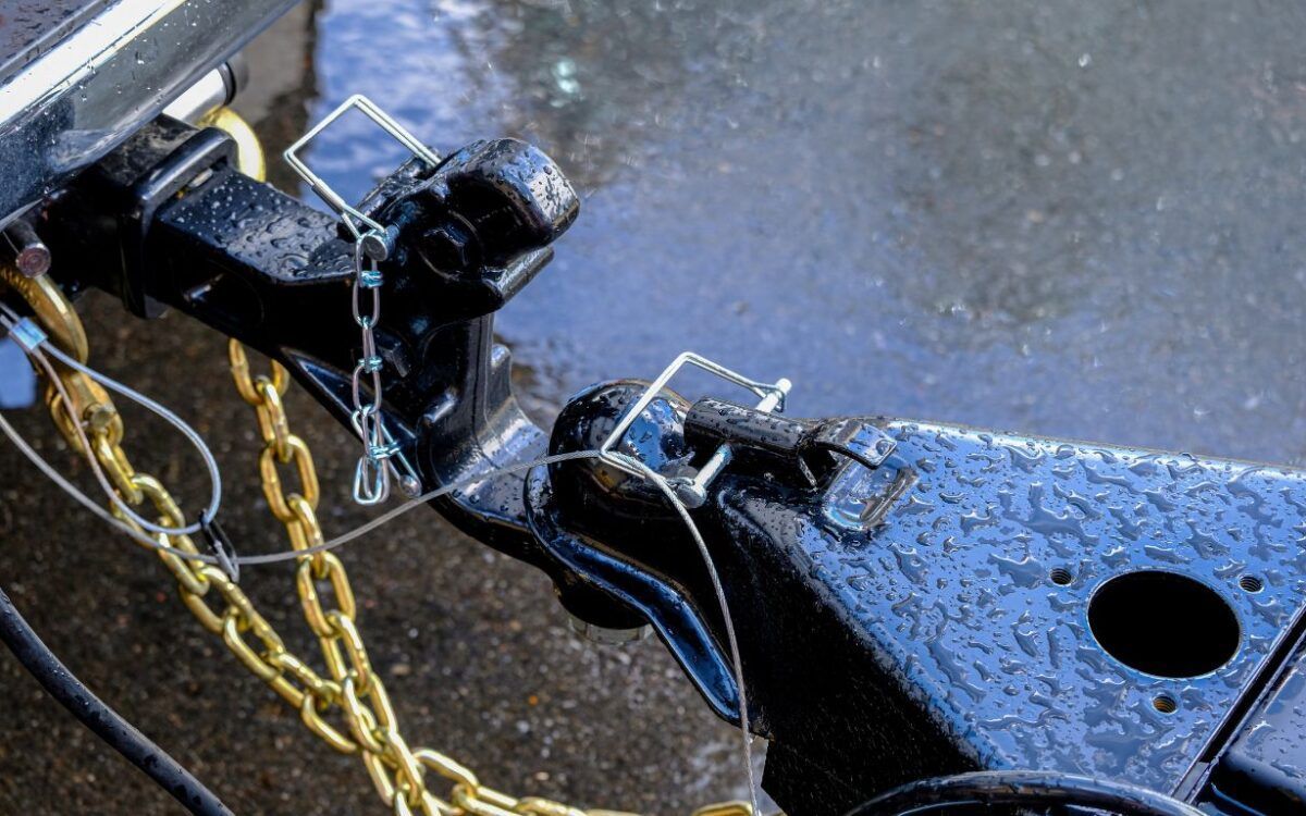 A close up of a trailer hitch with a chain attached to it.