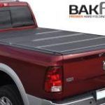 A red truck with a black bed cover on it.