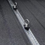 A close up of a metal railing with hooks attached to it.