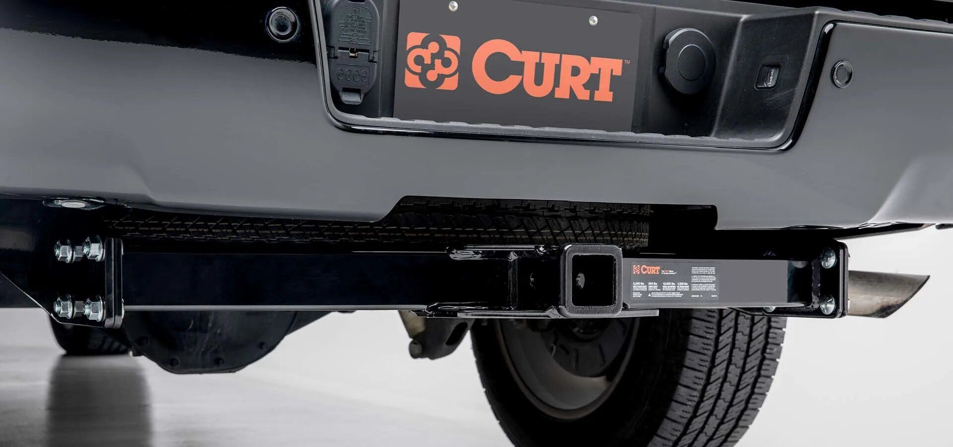 A black truck with a curt trailer hitch attached to it