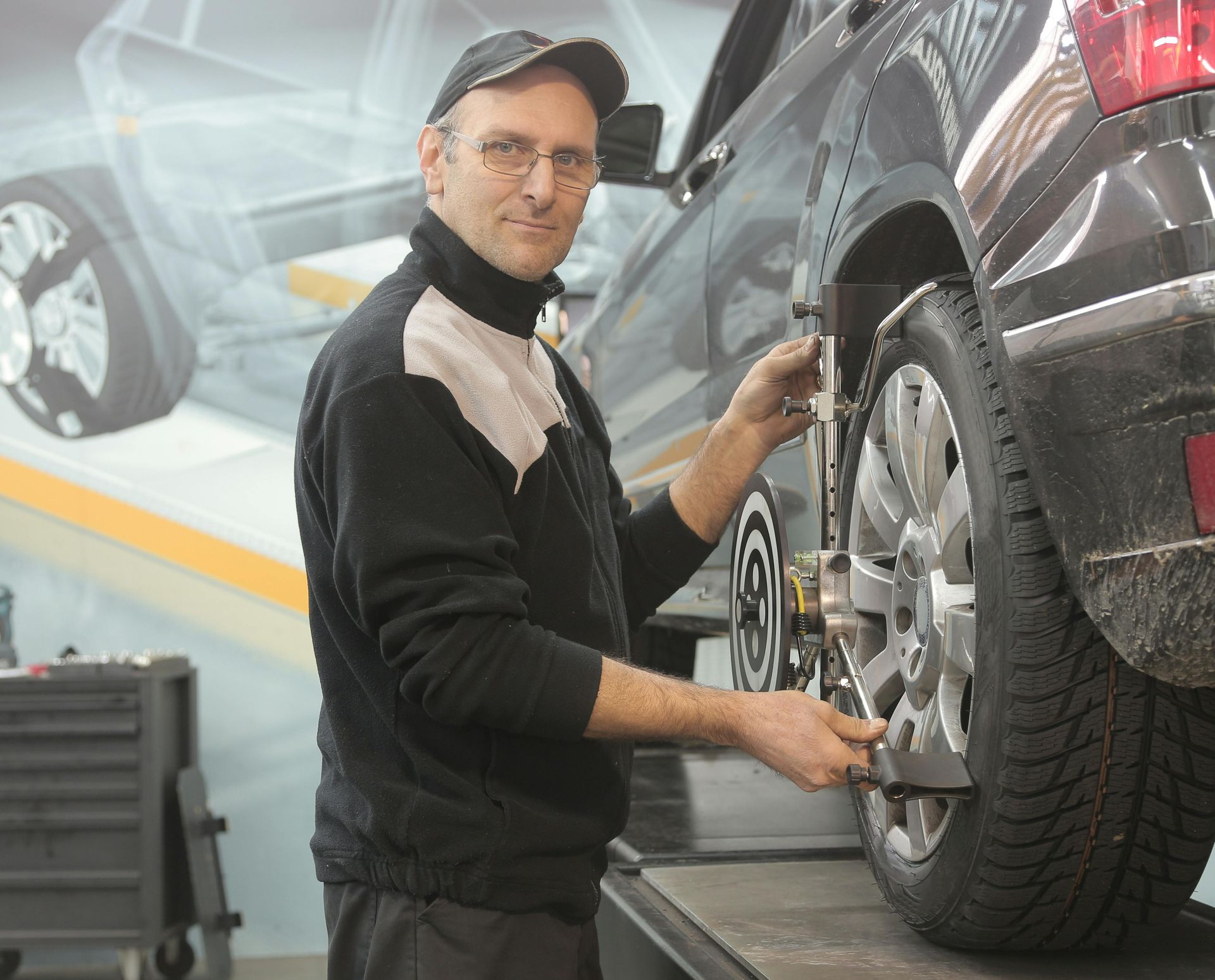A man is working on a car wheel in a garage